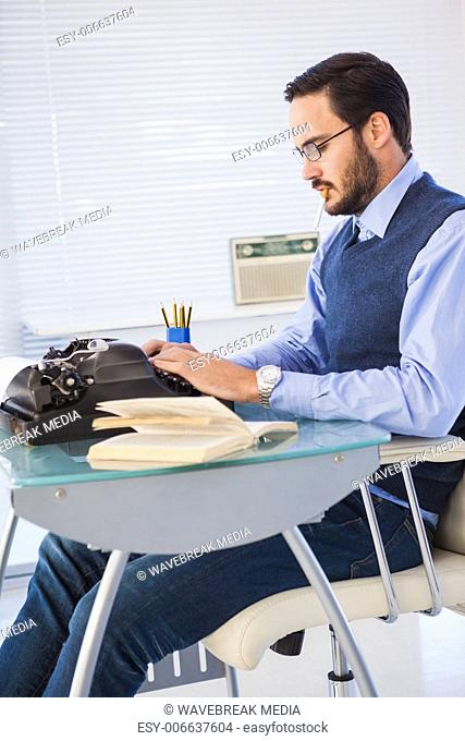Businessman working on typewriter while smoking
