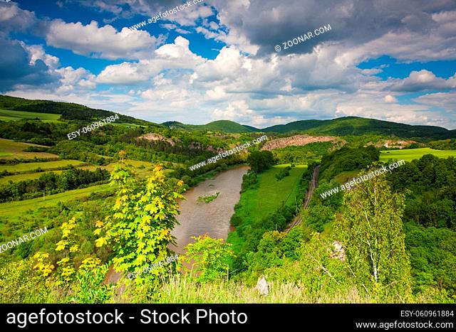 View from the hill into the valley with the Berounka river. Berounka river, limestone rocks, meadows, fields and railroad track