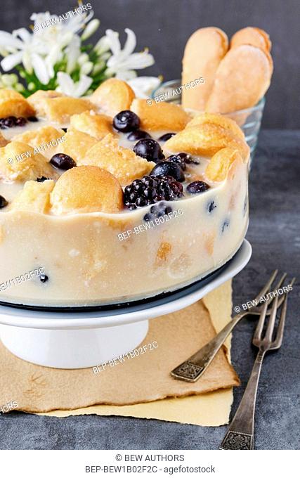 Blueberry and blackberry cheesecake with ladyfinger biscuits. Party dessert