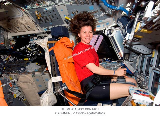 NASA astronaut Cady Coleman, Expedition 26 flight engineer, occupies the commander's station on the flight deck of space shuttle Discovery (STS-133) while...