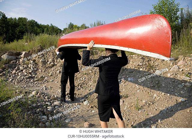 Business people carrying canoe