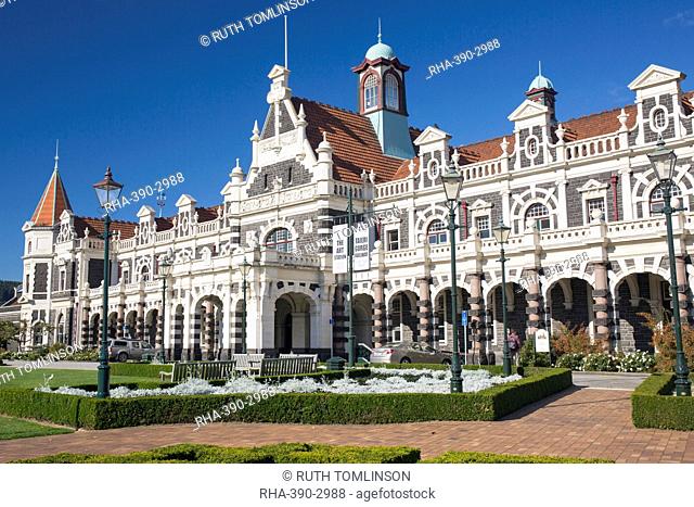 View from gardens to the imposing facade of Dunedin Railway Station, Anzac Square, Dunedin, Otago, South Island, New Zealand, Pacific