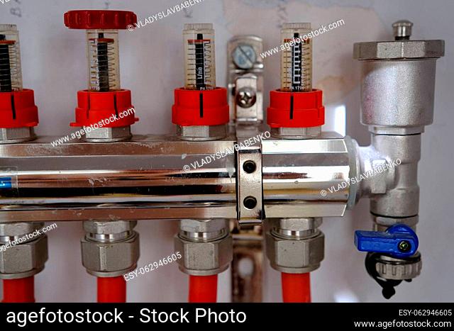 Heating system manifold valves for heat flooring and water supply in a country house. Pipes collector in a building under construction