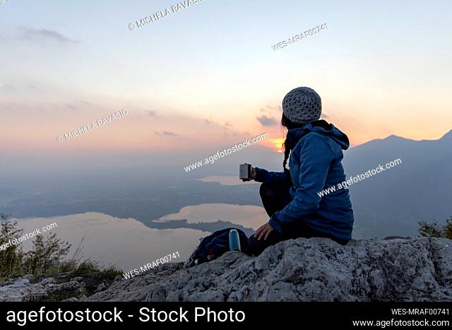 Woman enjoying coffee on sunset