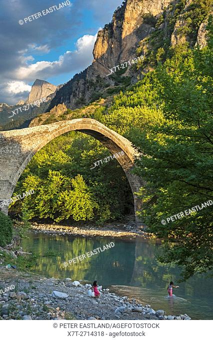 The old stone bridge across the Aoos river at Konitsa with Mount Tymfi in the background, Epirus, Northern Greece