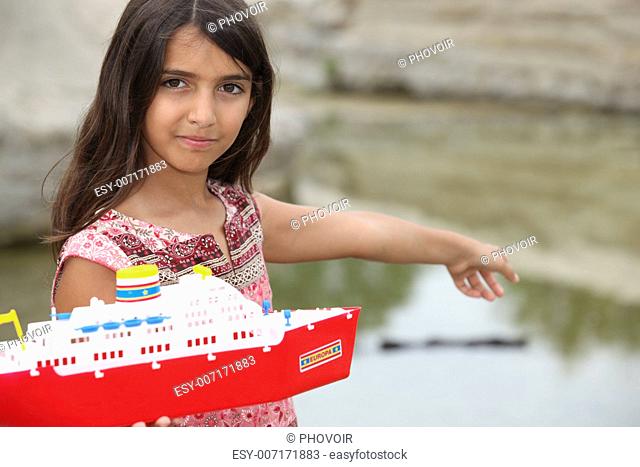 Little girl playing with a toy boat