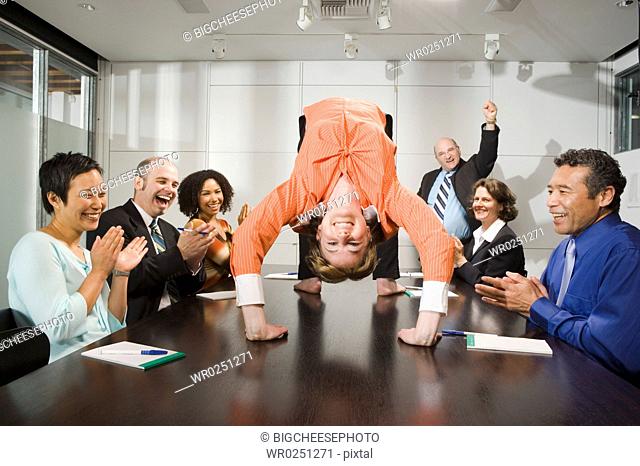 Businesswoman doing backbend at meeting