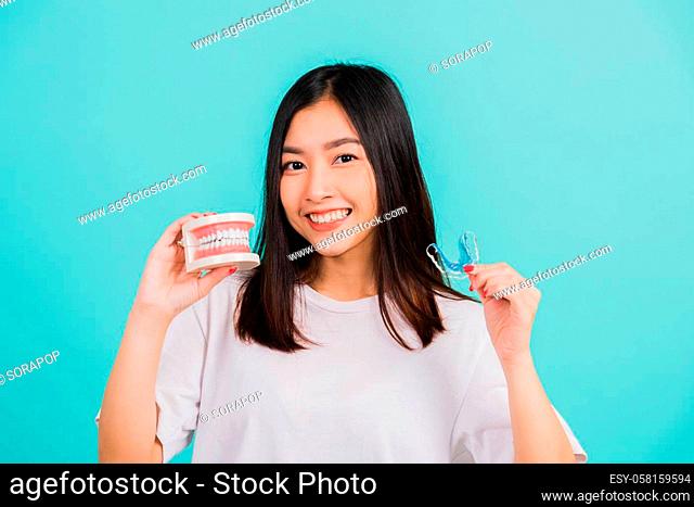 Portrait young Asian beautiful woman smiling holding silicone orthodontic retainers for teeth retaining tools after removable braces