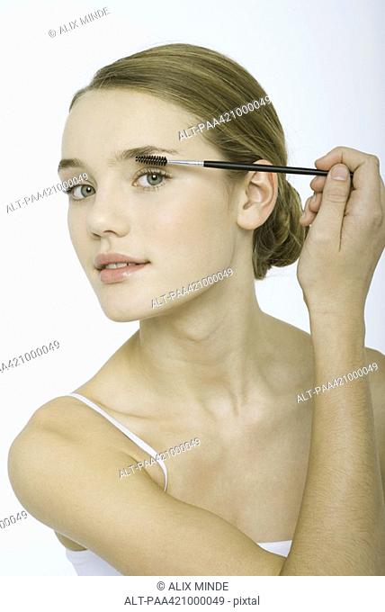 Teenage girl applying eye make-up