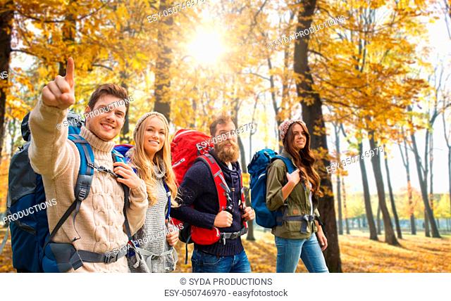 friends with backpacks hiking in autumn