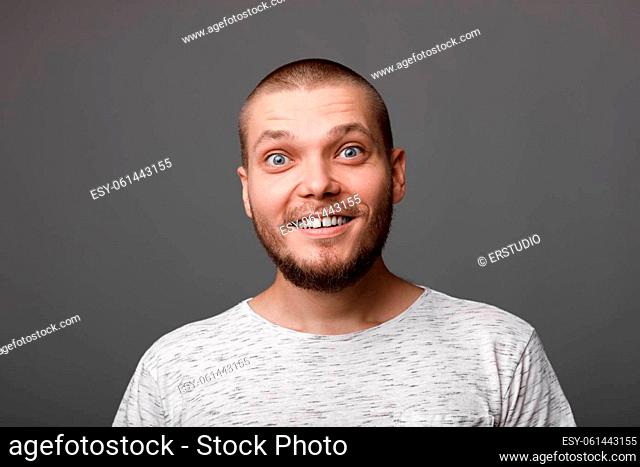 portrait of surprised young man on gray backround