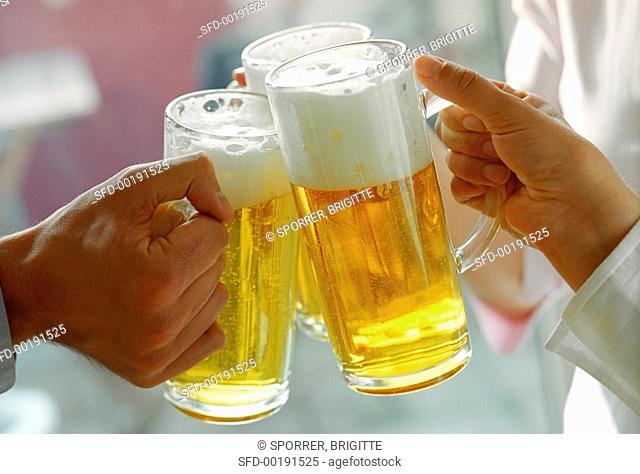 Hands clinking beer tankards (grainy effect)