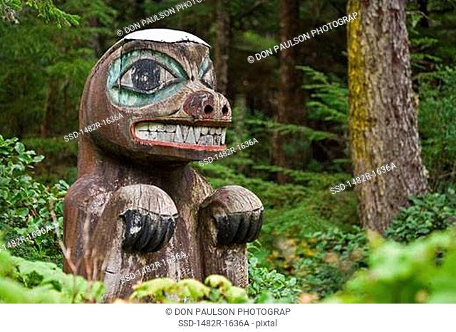 Totem poles of a bear in a forest, Kasaan Totem Park, Tongass National Forest, Alaska, USA