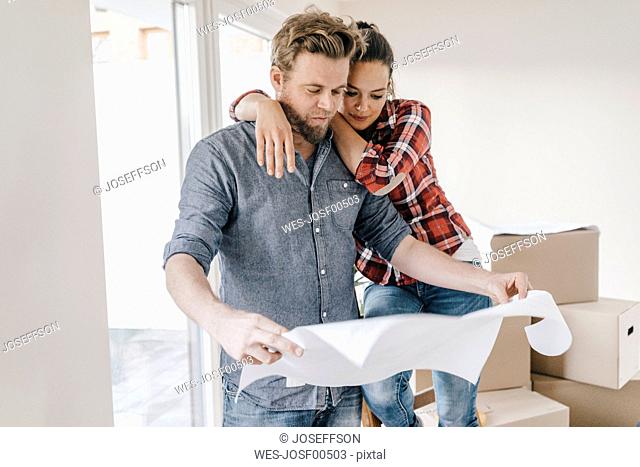 Couple looking at floor plan of theit new home