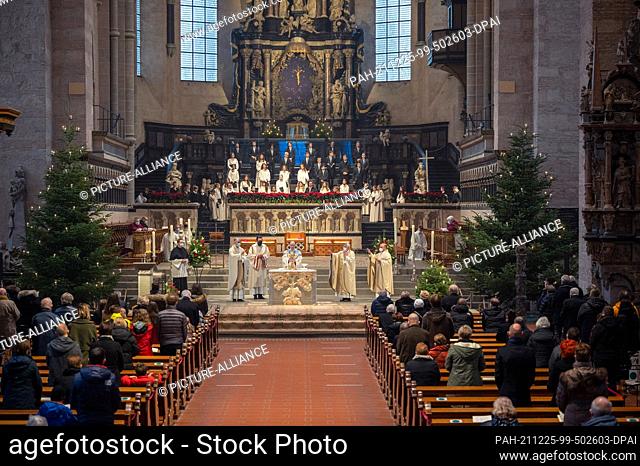 25 December 2021, Rhineland-Palatinate, Trier: Bishop Stephan Ackermann (M) holds the chalice at the offertory in the cathedral during the Christmas pontifical...