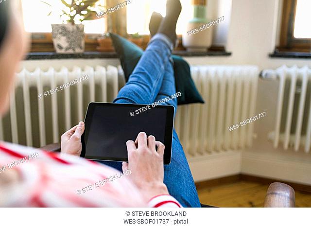Close-up of woman using tablet at home