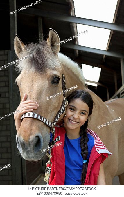 Portrait of a little girl with her favorite horse