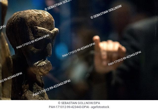 A man pointing to a wooden figure from the early 19th century during a press tour of the exhibition ""Hawai'i - Royal Island in the Pacific"" in the Linden...