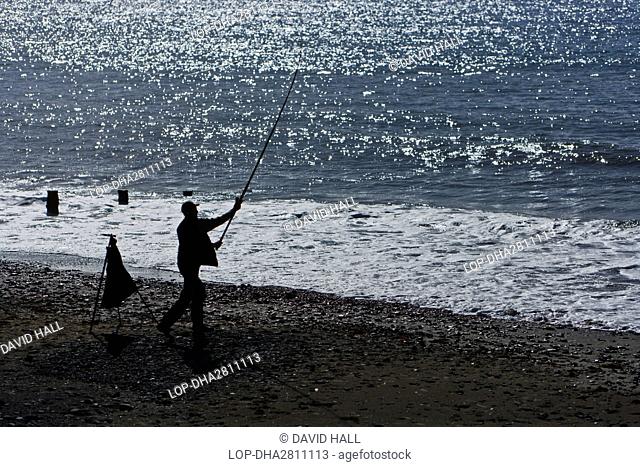 Wales, Gwynedd, Tywyn. An angler fishing from the beach at Tywyn, a seaside resort on Cardigan Bay