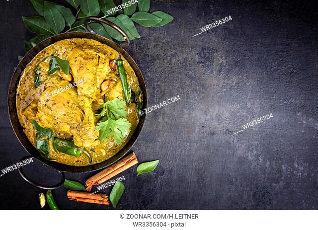 Traditional Indian curry chicken as close-up in a Korai with copy space right