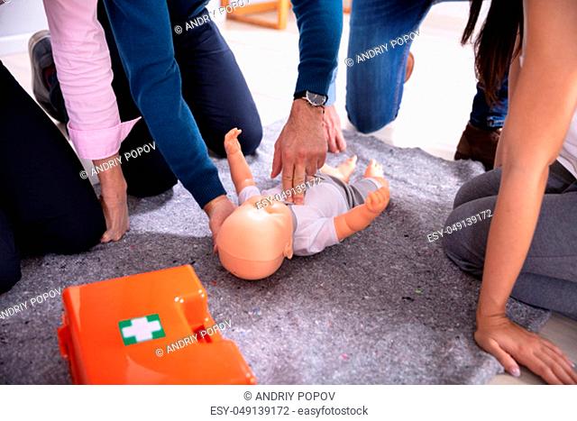 Specialist Giving Baby CPR Dummy First Aid Training To His Colleagues