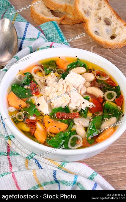 chicken soup with beans, spinach, tomatoes and other vegetables