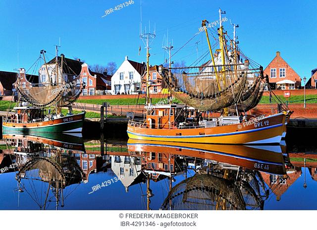 Shrimp boats in harbour in front of historical buildings, Greetsiel, Lower Saxony, Germany