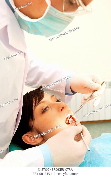A dentist examining a girlâ€™s teeth