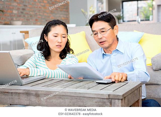 Worried couple checking bills