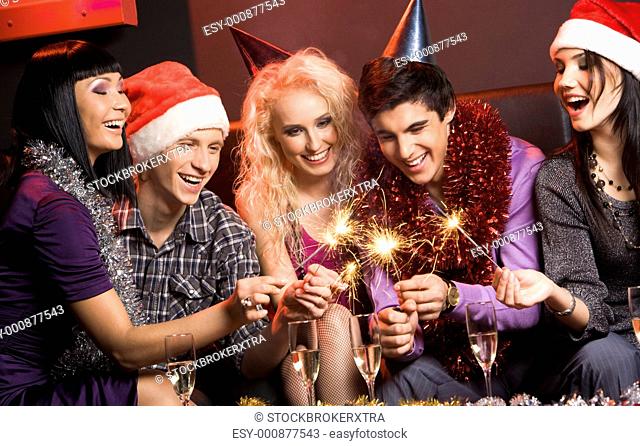 Portrait of laughing friends enjoying xmas lights at new year party