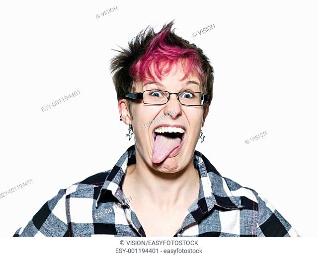 Portrait of a young expressive woman sticking out tongue in studio on white isolated background