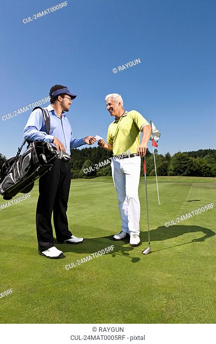 Golfer giving his card to the caddy