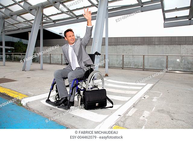 Businessman in wheelchair waiting for a taxi