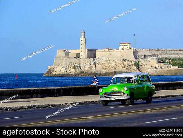 Classic fifties Chevrolet wagon, on the Malecon, with Morro Castle beyond, Centro, Havana, Cuba