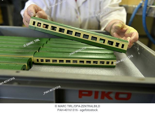 An employee presents a model wagon ot the deutsche Reichsbahn (DR) of the size HO at a factory of model railroad manufacturer Piko in Sonneberg, Germany