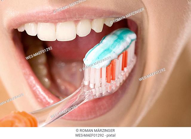 Young woman brushing her teeth, close up