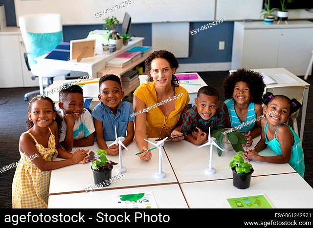 Portrait of african american students with caucasian young female teacher with windmill models