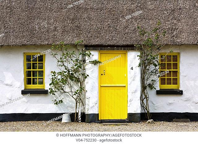Picturesque thatched cottage with yellow door and windows in Ballyvaughan, Ireland, Europe