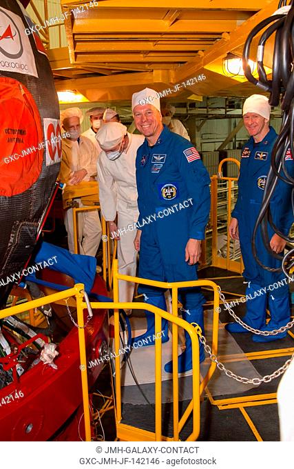 In the Integration Facility at the Baikonur Cosmodrome in Kazakhstan, Expedition 46-47 crewmember Tim Kopra of NASA (left) waits to board the Soyuz TMA-19M...