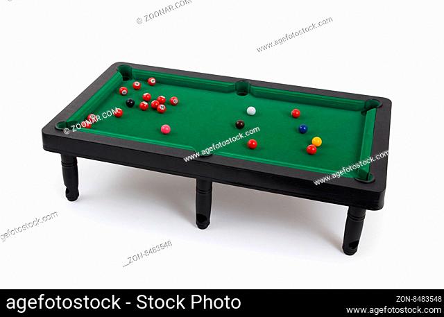 Miniature billiard table on a white background