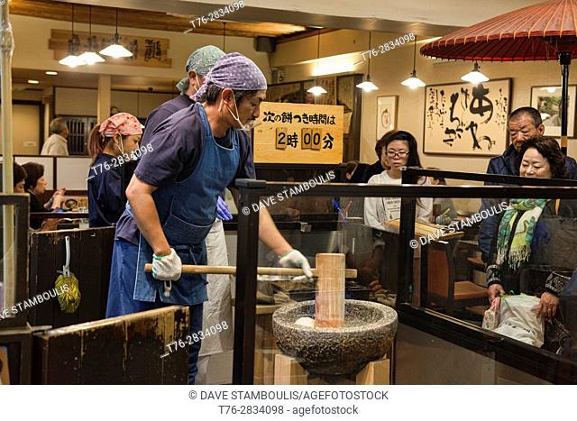 Pounding mochi rice snacks in Nishiki Market, Kyoto, Japan