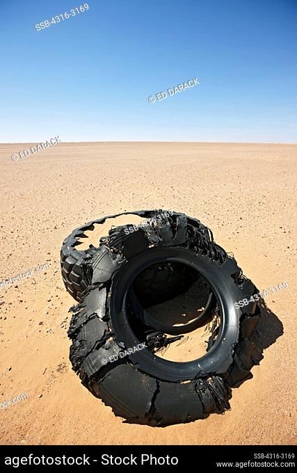 Abandoned tires, being slowly buried by the sands of the Sahara Desert, in the interior of Western Sahara