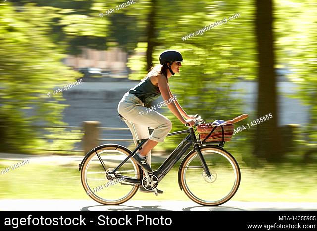 Cyclist in the meadows of the river Isar, Munich, Germany