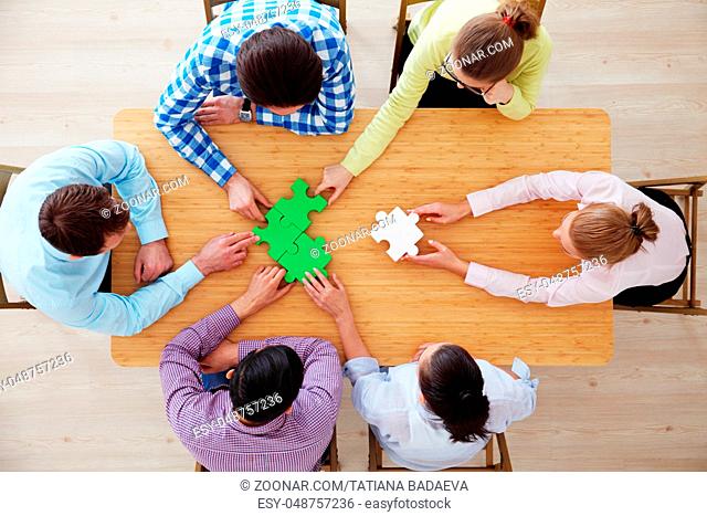 Hipster business successful teamwork concept, business people group assembling jigsaw puzzle, top view