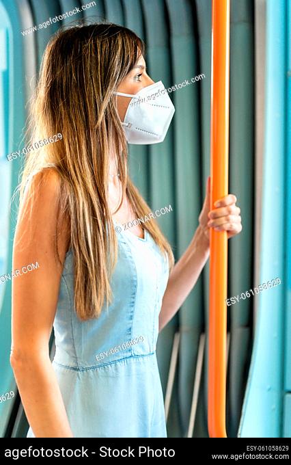 Woman passenger wearing medical hygiene protect mask. Standing inside subway train commuter in the city. High quality photo