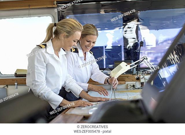 Two female deck officers working on a nautical map