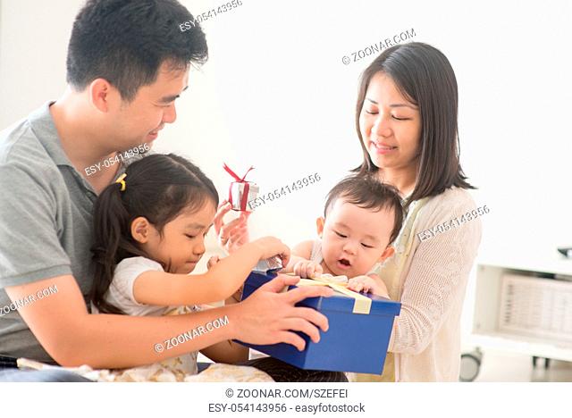 Parents and children boxing together. Asian family spending quality time at home, natural living lifestyle indoors