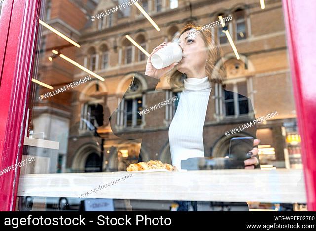 Businesswoman having a coffee break at a cafe in the city