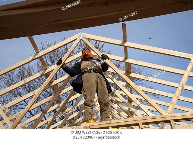 Warren, Michigan - Construction of a Habitat for Humanity house on the Martin Luther King holiday  A man installs trusses to support the roof