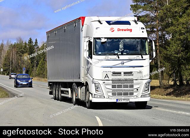 White Volvo FH semi trailer Drewing transports goods along highway on a sunny day of spring. Jokioinen, Finland. April 29, 2021